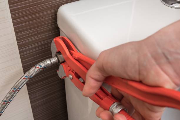 istock Plumber is repairing toilet cistern using a wrench 1312128434