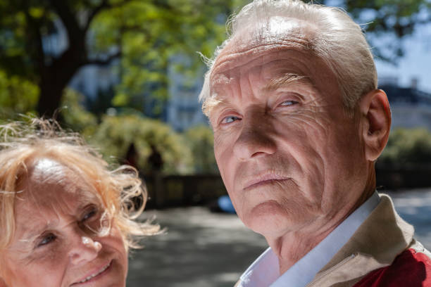 senior couple man looking at camera in public park - human face heterosexual couple women men imagens e fotografias de stock