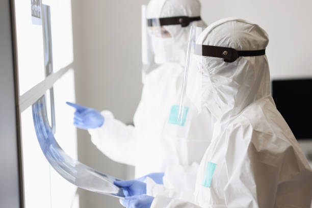 istock Two doctors in protective suits and masks examine an X-ray 1312130756