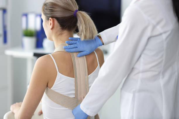 doctor fixes posture corrector to patient closeup - bustiers imagens e fotografias de stock