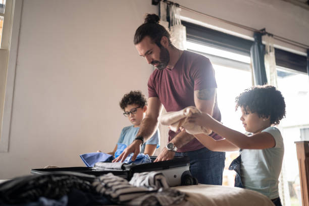 istock Kids helping father packing his suitcase at home 1312131193