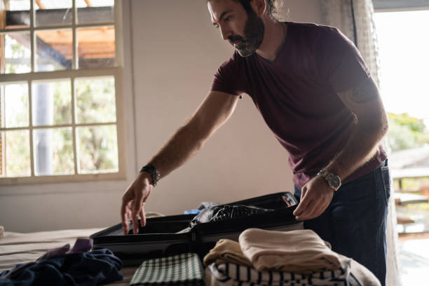istock Man packing his backpack for a trip at home 1312131195
