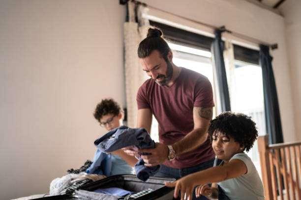 Kids helping father packing his suitcase at home