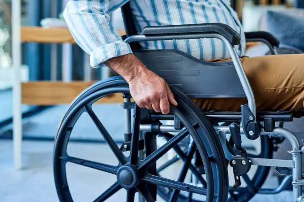 Cropped shot of an unrecognizable wheelchair bound man in his apartment