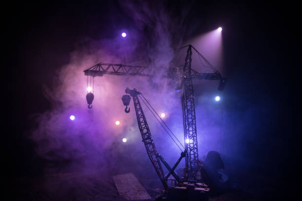 istock Abstract Industrial background with construction crane silhouette over amazing night sky with fog and backlight. Tower crane against the foggy sky at night. 1312133725