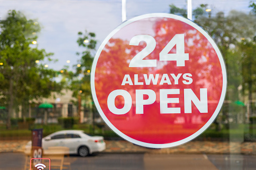 24 Hours Always Open Sign in front of the coffee shop cafe or co-working space in the town. 24 Hours Always Open Sign of department store shop near roadside. Business shop concept