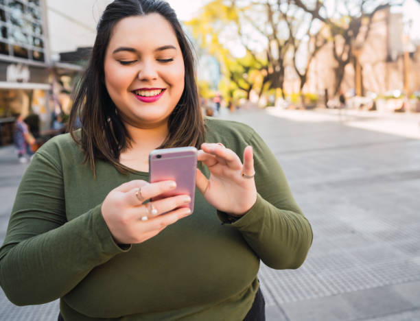 istock Young plus size woman using her mobile phone. 1312138930