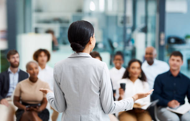 Learning on the job Rearview shot of an unrecognizable businesswoman giving a presentation in the office boardroom corporate business stock pictures, royalty-free photos & images