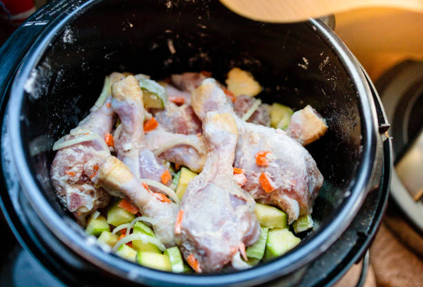 istock raw chicken legs and vegetables are mixed in a non-burner multicooker bowl 1312141256