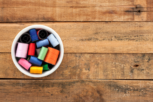 Top view of bowl with multi colored spools of thread