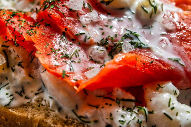 Close up of half a roll topped with salmon and shrimp,