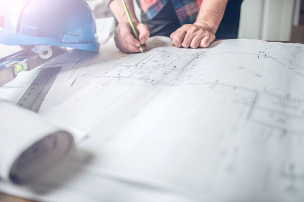 Site superintendent reviewing the drawings Hands of an architect, engineer or contractor pointing on the plan. He is on site for construction management. superintendent stock pictures, royalty-free photos & images