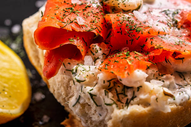 Close up of half a roll topped with salmon and shrimp,