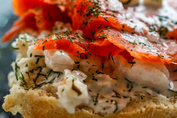 Close up of half a roll topped with salmon and shrimp,