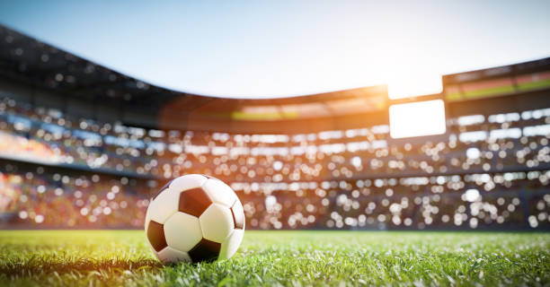 Football soccer ball on grass field on stadium stock photo