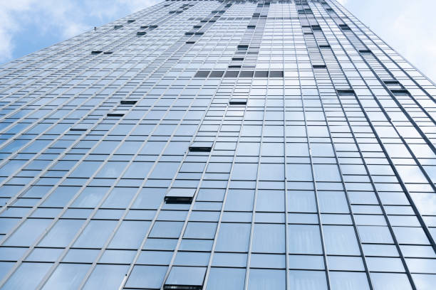 istock Modern glass office buildings reflecting blue sky and white clouds 1312143725