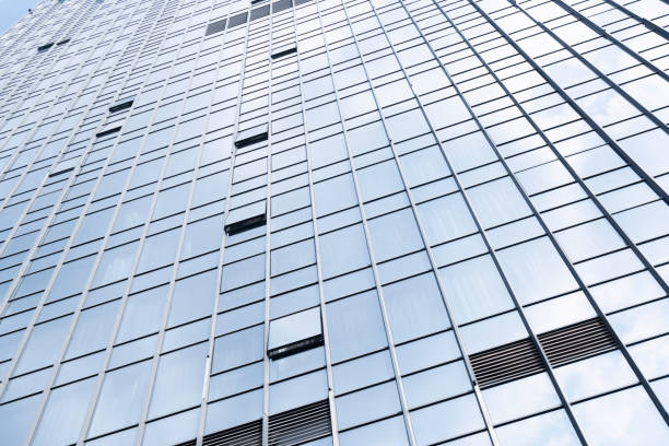 istock Modern glass office buildings reflecting blue sky and white clouds 1312143728