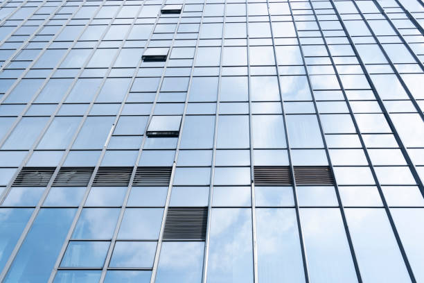 istock Modern glass office buildings reflecting blue sky and white clouds 1312143758