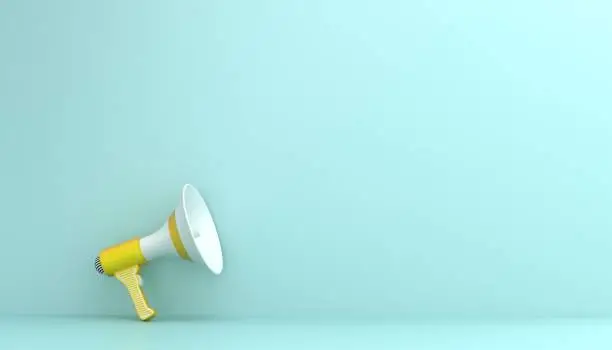 Photo of Yellow megaphone on blue background