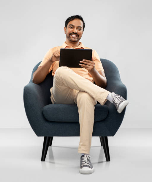 istock happy indian man with tablet pc computer in chair 1312146334