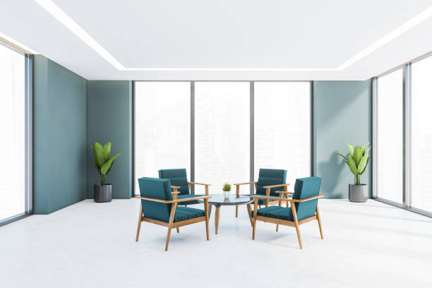 istock Blue armchairs in white and blue office room with plants and windows 1312146452