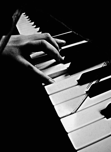 Woman hand playing piano, black and white