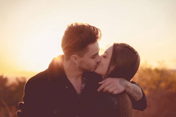 istock Couple kissing at sunset with the sun behind them 1312147604