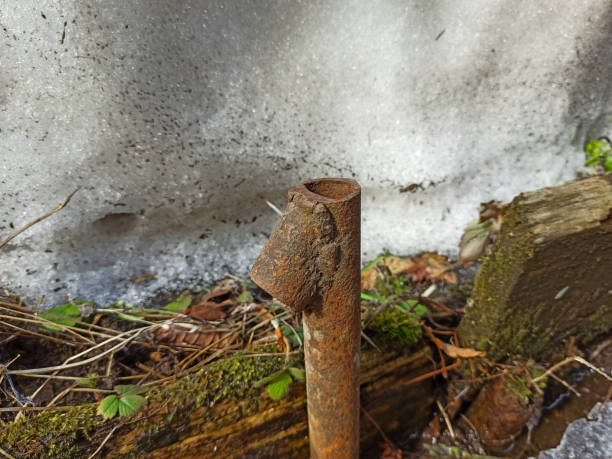 istock Old rusty pipe stuck into the ground, snow in the background 1312147958