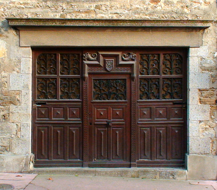 public view from the street of a solid and superb wooden door of a Breton mansion.