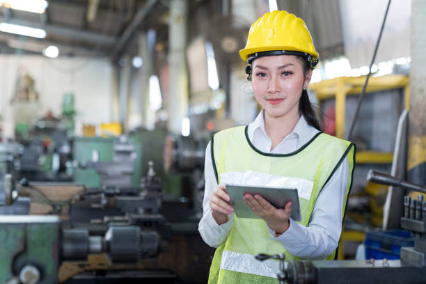 istock Engineers female and skilled technicians are maintaining machinery. Professional technicians are holding a tablet to control work in industrial plants. 1312148954