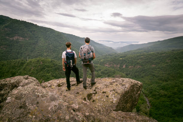 istock Two male hikers enjoying in the view while standing on a mountain peak 1312153794