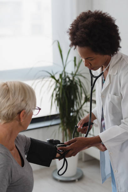 クリニックで高齢女性の血圧をチェックする女性医師 - visit hospital patient senior adult ストックフォトと画像