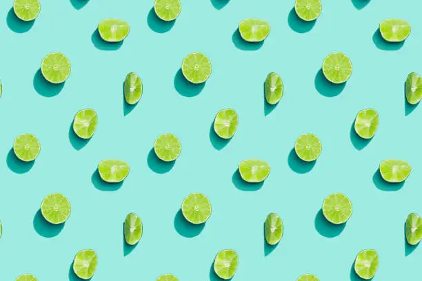 Summer fruits top view, bright juice citrus green lime on blue background. Healthy fruit food.