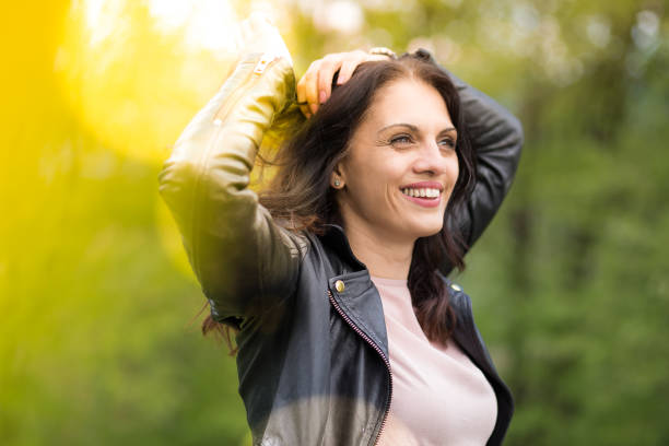 belle femme d’âge moyen en veste en cuir noir souriant largement. - women autumn beauty in nature smiling photos et images de collection