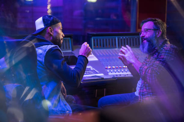 istock Two male musicians discussing final sound in recording studio control room. 1312158986