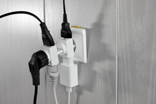 istock Multiple plugs in wall electrical outlet is dangerous overload, close-up 1312159487