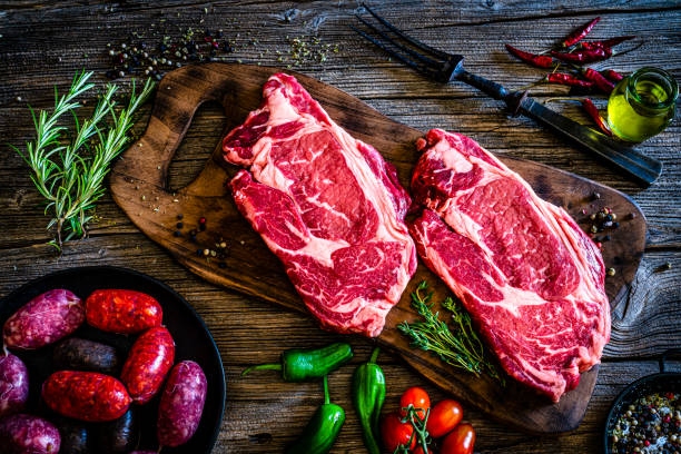 istock Two raw Angus beef steaks and sausages with spices and herbs 1312160679