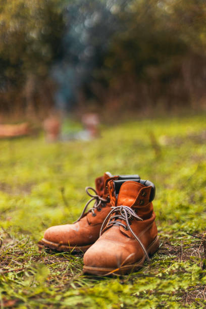 istock Close up of hiking boots drying out next to campfire during sunset 1312163309