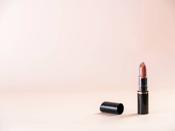 istock Open lipstick with a cap lying next to it on a powdery background. Side view. 1312164032