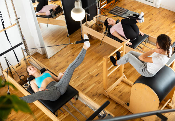 istock Group of women doing exercises during pilates reformer class 1312165490