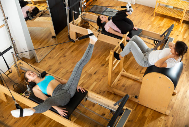 istock Fitness studio with women practicing Pilates on reformer 1312165533