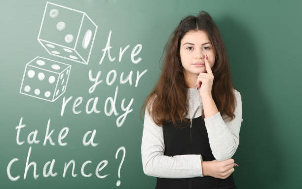 istock Pre-adolescent girl ponders her next step. Dice drawn in chalk 1312165680