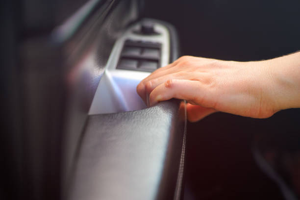 Person hand on car interior door handle. Close-up