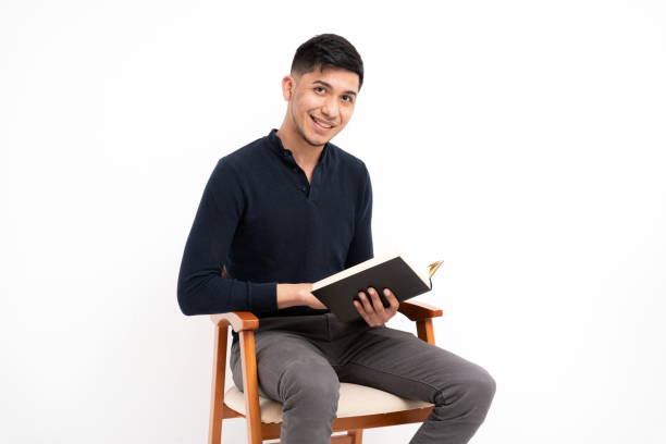 istock Latin man with book in hands smiling looking at camera on white background 1312171880
