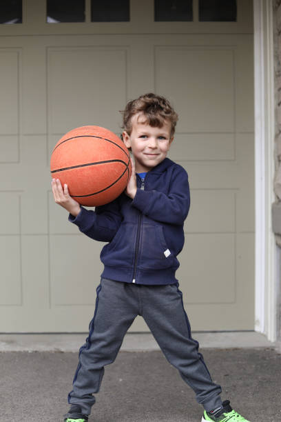 istock Little boy playing basketball on his front yard 1312173015