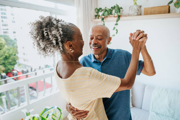 Carefree senior couple dancing in the living room Carefree senior couple dancing in the living room DisruptAgingCollection stock pictures, royalty-free photos & images