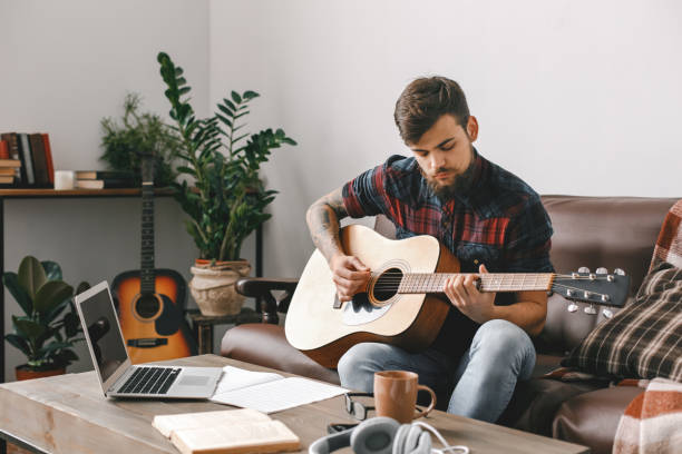 istock Young guitarist hipster at home with guitar sitting workplace 1312173774