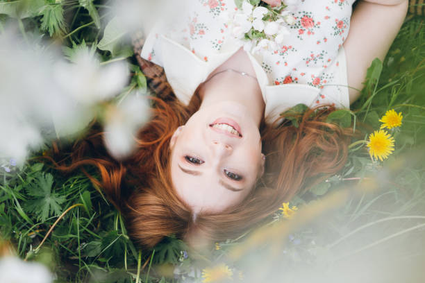 istock Red-haired girl walks in a spring blooming apple orchard 1312173851