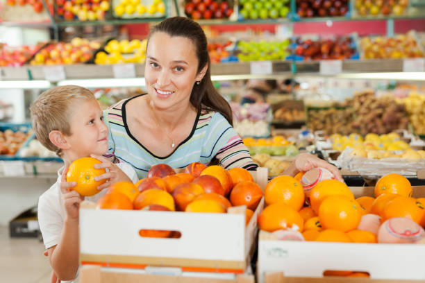 istock kid with his mother selecting  oranges 1312175044