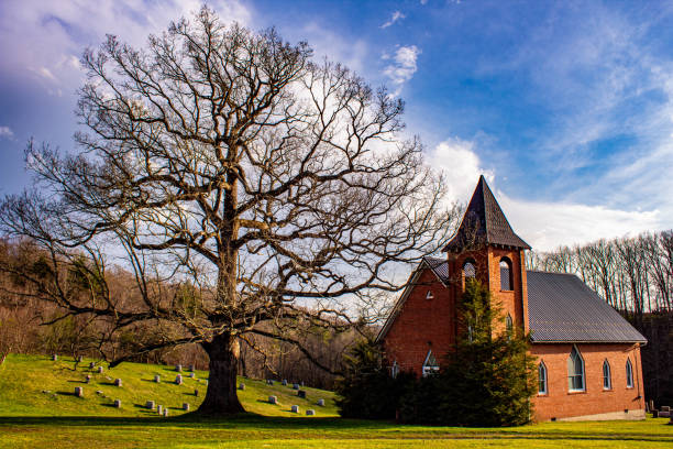 istock Old country church and massive tree 1312178390